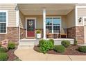 Inviting front porch with stone accents, space for seating, and well-maintained landscaping at 704 Woodbridge Dr, Woodstock, GA 30188