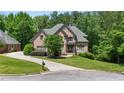 Charming home boasts a long driveway, lush lawn, and mature trees creating a serene setting at 1029 Laurel Grove Cts, Suwanee, GA 30024