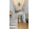 Bright foyer with hardwood floors, stairs and a decorative chandelier creating a grand entrance at 1029 Laurel Grove Cts, Suwanee, GA 30024