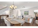 Inviting dining room with wood floors, an elegant chandelier, and views into the adjacent living space at 3585 Adelaide Xing, Brookhaven, GA 30319