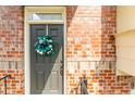 Close up of the front door featuring a festive wreath and brick surround adding warmth and charm at 3585 Adelaide Xing, Brookhaven, GA 30319