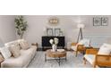 Cozy living room features stylish decor, a comfortable sofa, accent chairs, and a patterned rug at 3585 Adelaide Xing, Brookhaven, GA 30319