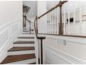 Elegant staircase with wooden steps and white railings leading to the upper levels of the home at 3585 Adelaide Xing, Brookhaven, GA 30319