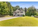 Traditional home with a well-manicured lawn and mature trees in a residential neighborhood at 3835 Annandale Ln, Suwanee, GA 30024