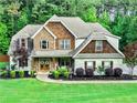Beautiful two-story home with stone and shake siding, well-manicured lawn, and professional landscaping at 100 Chantilly Ln, Fayetteville, GA 30215