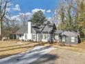 Charming home boasts a well-manicured front lawn, white paint, black trim, and a chimney at 1571 Boulevard Lorraine Sw, Atlanta, GA 30311