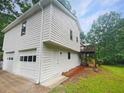 View of the house exterior featuring a 2-car garage and a small deck area at 2325 Sebring Sw Ct, Marietta, GA 30064