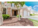 Attractive townhome showcasing a brick facade, a covered entrance, and a well-kept landscaped front yard at 3453 Dianthus Ln, Lawrenceville, GA 30044