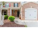 Inviting townhome entrance featuring a brick facade, covered porch, and a well-maintained front yard at 3453 Dianthus Ln, Lawrenceville, GA 30044