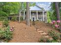 Charming two-story home with stone facade, white columns, and a beautifully landscaped front yard at 6300 Mountain Brook Ln, Atlanta, GA 30328
