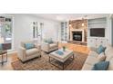 Bright and airy living room featuring hardwood floors, a brick fireplace, and stylish, comfortable seating at 6300 Mountain Brook Ln, Atlanta, GA 30328