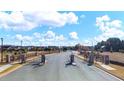 Community entrance showcases a paved road leading into the neighborhood with manicured lawns and attractive homes at 133 Canal St, Hampton, GA 30228