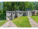 Gray painted house with a one-car garage and a double wide driveway at 2025 Venetian Sw Dr, Atlanta, GA 30311