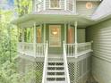 Close-up of a charming front porch featuring a railing, stairs, and cozy seating area surrounded by greenery at 284 Due West Ct, Dallas, GA 30157
