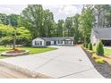 Modern farmhouse with a pristine lawn, long driveway and lush, mature trees at 2265 Hillbriar Dr, Buford, GA 30518