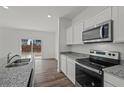 Galley kitchen featuring granite countertops, stainless appliances and backyard access at 2348 Argento Cir, Dacula, GA 30019