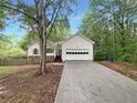One-story home featuring white siding, stone accents, attached garage, and concrete driveway at 3458 Natalie Ct, Loganville, GA 30052