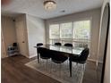 A sleek dining room featuring dark table and chairs, with natural light from the oversized windows at 3050 Camden Way, Alpharetta, GA 30005