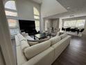 A bright living room features soaring windows, a comfortable L-shaped couch and a large TV at 3050 Camden Way, Alpharetta, GA 30005