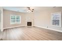 Bright living room with fireplace, hardwood floors, and large windows showcasing the backyard at 909 Pine Cove Dr, Lilburn, GA 30047
