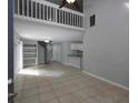 Bright living space with high ceilings, spiral staircase, tiled flooring, and open layout to kitchen at 1903 Brittania Cir, Woodstock, GA 30188