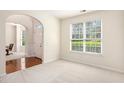 Bright, carpeted living room with large window and arched doorway to foyer at 4535 Howell Farms Nw Rd, Acworth, GA 30101