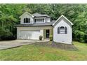 Charming two-story home with a well-manicured lawn, garage, and classic architectural details at 4278 Trotters Ln, Auburn, GA 30011