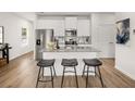 Modern kitchen with white cabinets, granite countertops, stainless steel appliances, and three black barstools at 6427 Rosetta Dr # 64, South Fulton, GA 30331
