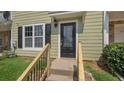 Close-up of the front entrance with a decorative glass door, stairs, and manicured lawn at 6964 Oakhill Cir, Austell, GA 30168