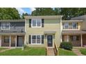 Charming two-story townhome with light green siding, black shutters, and a inviting front entrance at 6964 Oakhill Cir, Austell, GA 30168