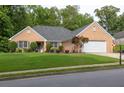 Well-maintained brick home with lush green lawn and mature landscaping for great curb appeal at 1520 Great Oaks Dr, Lawrenceville, GA 30045