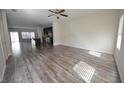 Open-concept living space featuring wood-like floors, a ceiling fan, and plenty of natural light at 1560 Iris Walk, Jonesboro, GA 30238