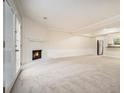 Open-concept living room featuring a fireplace, seamlessly connected to the kitchen, and neutral carpet at 7004 Pat Mell Se Pl, Smyrna, GA 30080