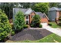 Beautiful brick home with a manicured front yard, mature trees, and an attached two-car garage at 220 Galesburg Dr, Lawrenceville, GA 30044