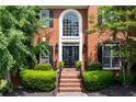 Inviting brick entryway with double doors, lush greenery, and elegant black accents at 220 Galesburg Dr, Lawrenceville, GA 30044