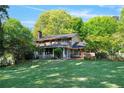 Expansive backyard with lush green lawn and mature trees, featuring a screened in porch at 4261 Brookview Se Dr, Atlanta, GA 30339