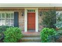 Inviting front entrance showcasing a brick facade, lantern sconces, and manicured shrubbery at 4261 Brookview Se Dr, Atlanta, GA 30339