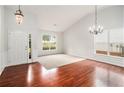 Bright living room featuring wood floors, fresh neutral paint, statement chandeliers, and a large window at 712 Brambling Way, Stockbridge, GA 30281