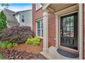 Inviting front entrance with a black door, decorative sidelight, and beautifully landscaped garden at 813 Poplar Ter, Canton, GA 30115
