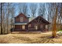 Charming log cabin featuring a welcoming front porch, exposed beams, and well-kept landscaping at 1225 Pitts Chapel, Newborn, GA 30056