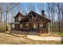 Charming log cabin featuring a welcoming front porch, exposed beams, and well-kept landscaping at 1225 Pitts Chapel, Newborn, GA 30056