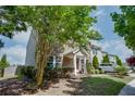 Well-maintained townhome featuring lush landscaping, a welcoming entrance, and ample natural light at 1570 Shire Village Dr, Sugar Hill, GA 30518