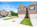 Brick townhome with a two-car garage and a concrete driveway surrounded by green grass at 2170 Trelipe Dr, Lawrenceville, GA 30044