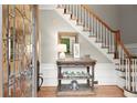 Inviting foyer featuring leaded glass door, hardwood floors, stairs, and decorative table and staircase at 194 Sentinel Se Pl, Marietta, GA 30067