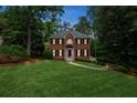 Elegant brick home featuring a well-manicured lawn, mature trees, and inviting entrance way at 2622 Murdock Rd, Marietta, GA 30062
