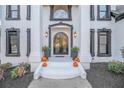 Inviting front entrance with white painted brick, decorative planters, and arched double doors at 4519 Mossey Dr, Lithonia, GA 30038