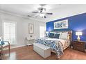 Bedroom featuring a striking accent wall, hardwood floors, a ceiling fan, and ample natural light at 989 Brownstone Ln # 16, Marietta, GA 30008
