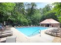 Community pool surrounded by lounge chairs and lush greenery, perfect for relaxation and recreation at 989 Brownstone Ln # 16, Marietta, GA 30008