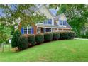 Landscaped front yard with green lawn, mature trees, and neatly trimmed hedges enhances curb appeal at 1847 Oak Rd, Snellville, GA 30078