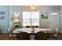Bright dining room with wooden table and chairs and a large window at 2410 Clock Face Ct, Lawrenceville, GA 30043